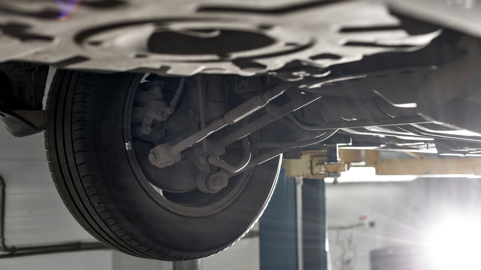 rear car suspension. the garage mechanic raised the car on the lift